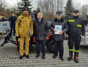 Komendant z Wójtem Cycowa oraz druhami OSP stojący przy quadzie